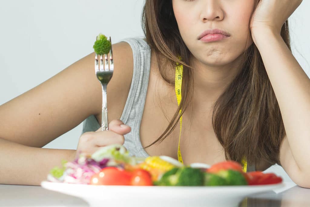 Unhappy woman with food on her fork