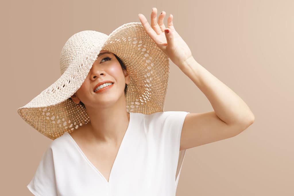 Young woman wearing a hat to shield herself from the sun